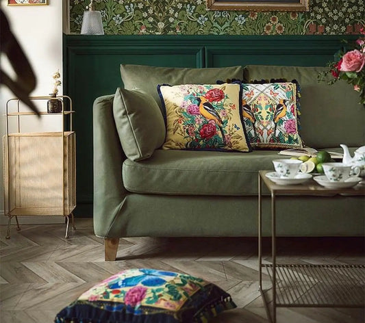 Green velvet sofa with floral pillows in luxury homeware for a fresh start in style.