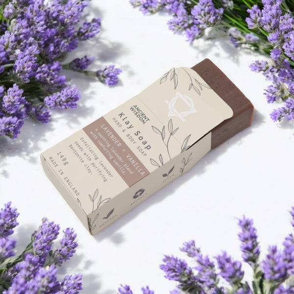 Klay Soap - Lavender & Vanilla. A rectangular bar of natural, light purple-coloured soap with visible lavender seeds for gentle exfoliation. The soap is infused with Bentonite clay for deep cleansing and has a soothing lavender and vanilla scent.