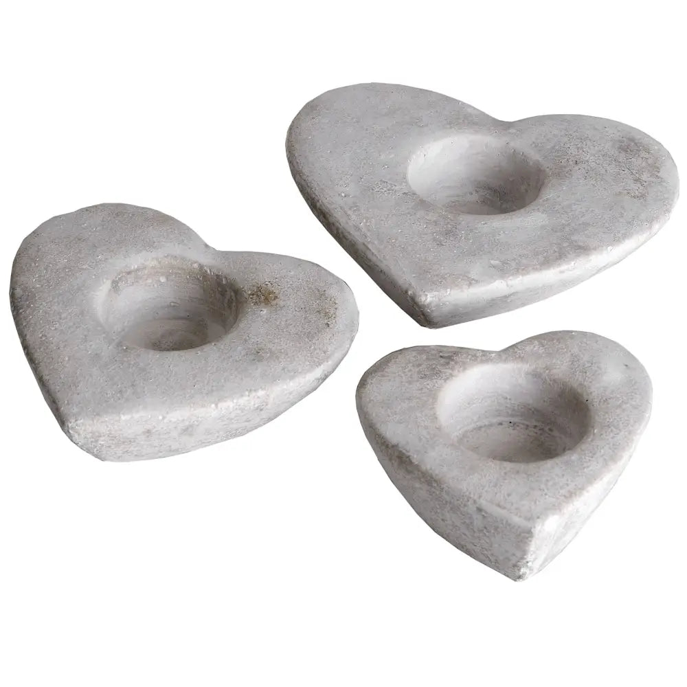 Heart tea light holders in heart-shaped concrete with circular indentations