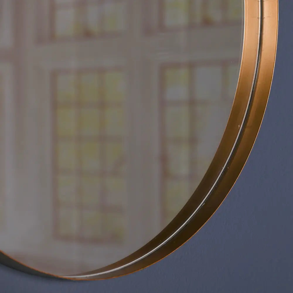 Circular gold round wall mirror with a curved edge for stylish home decor