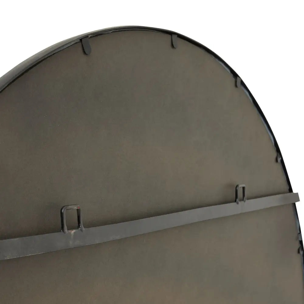 Curved metal panel detail on a black large circular metal wall mirror with support bar