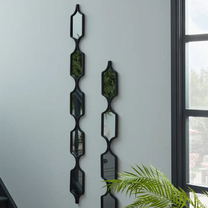 Decorative wall-mounted planters with geometric shapes around a striking decorative black hanging mirror