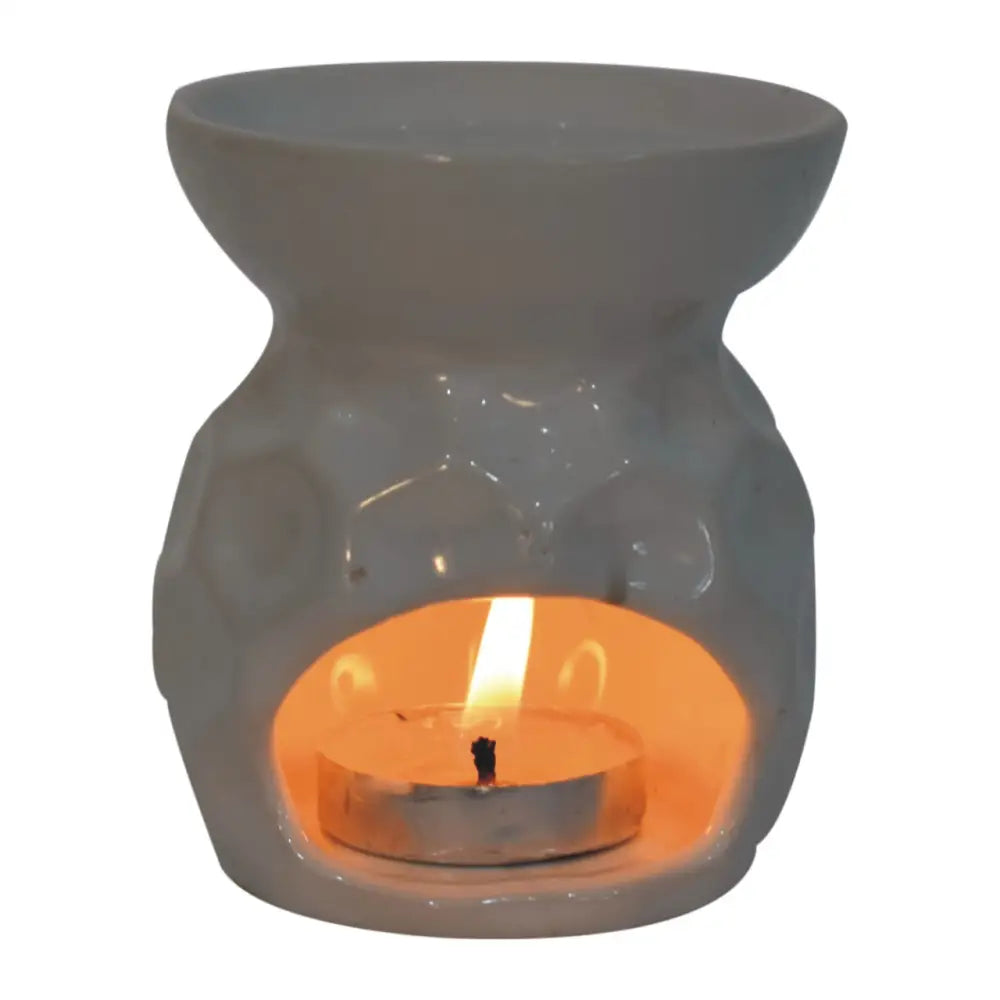 Ceramic Taya White Oil Burner with a lit candle and two wax melts for a cozy vibe