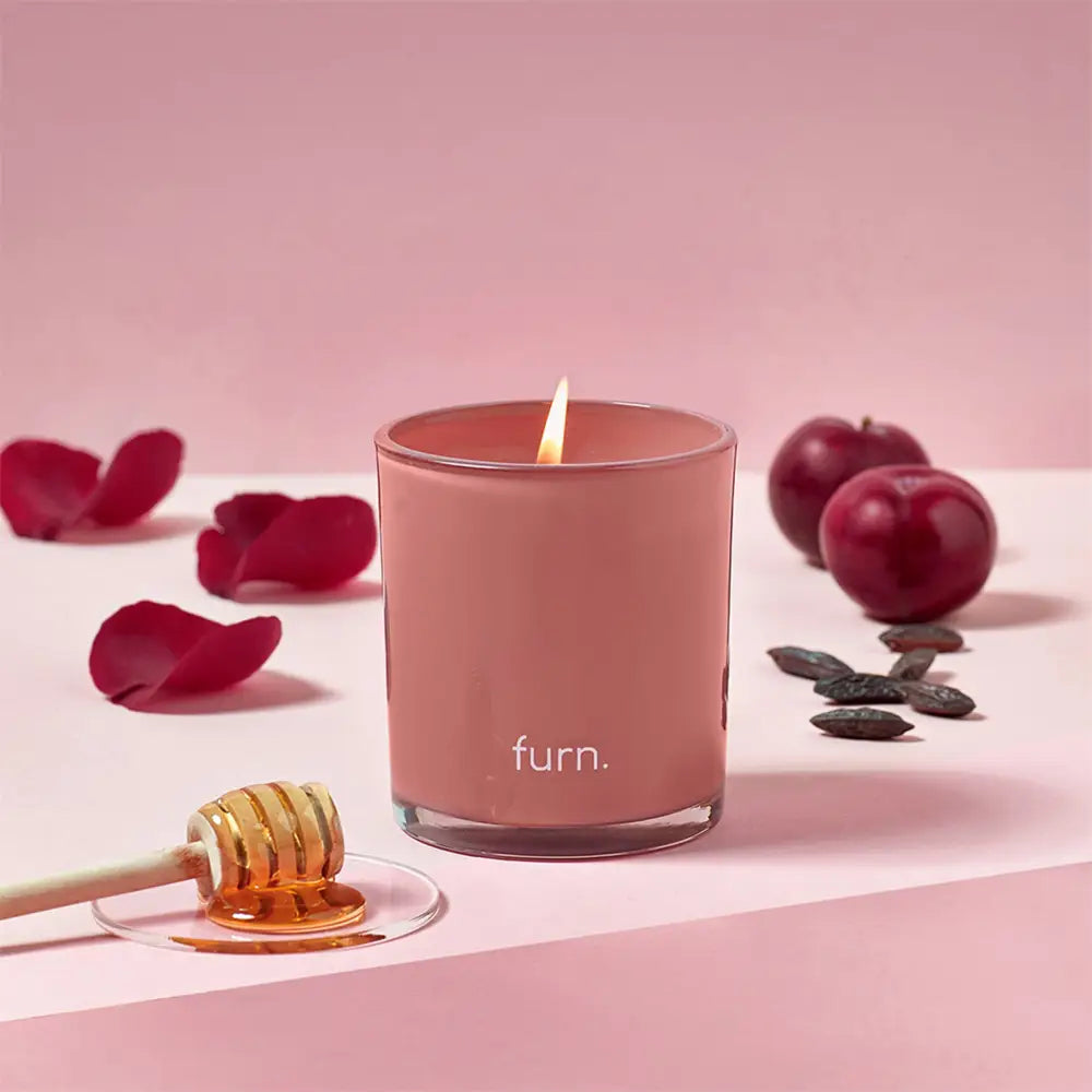 Pink tonka scented glass candle labeled Furn with divine bergamot fragrance