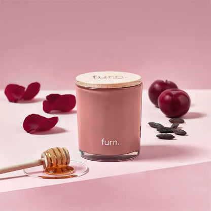 Pink cylindrical candle container labeled furn from Bee Happy Divine Bergamot Tonka Scented Glass