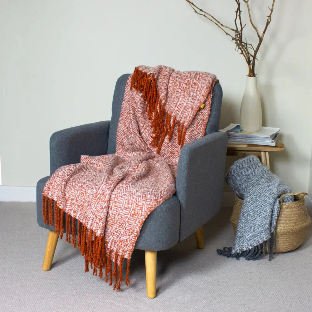 Gray armchair with wooden legs and Cozy Weaver Throw in Herringbone Design draped